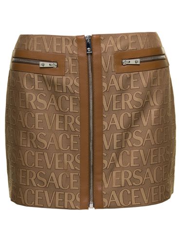 Mini -skirt With All-over Logo Lettering Print In Canvas Woman - Versace - Modalova