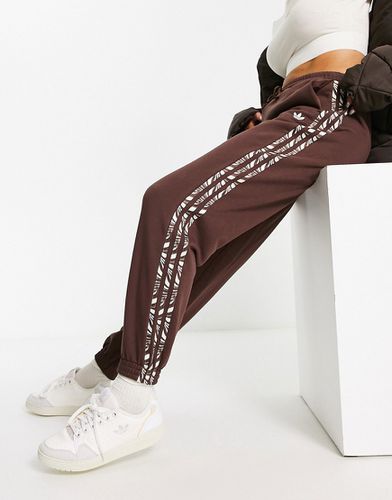 Animal Abstract - Joggers marroni con stampa zebrata sulle tre strisce - adidas Originals - Modalova