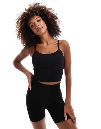 Icon - Canotta da yoga nera a coste senza cuciture con reggiseno interno - ASOS - Modalova