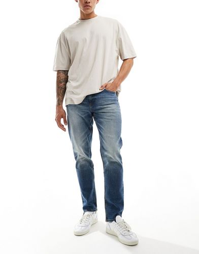 Jeans affusolati elasticizzati lavaggio medio vintage - ASOS DESIGN - Modalova