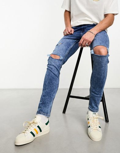 Jeans skinny con strappi sulle ginocchia lavaggio medio - ASOS DESIGN - Modalova
