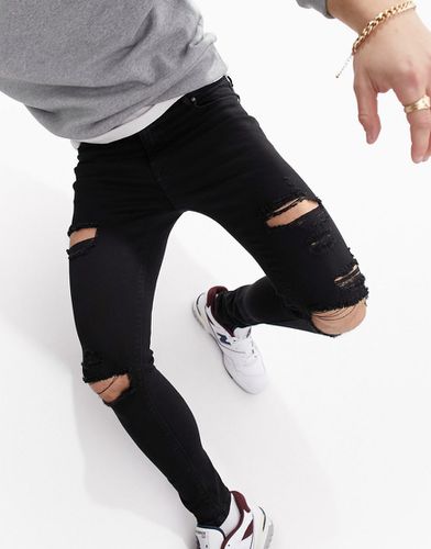 Jeans spray on elasticizzati neri strappati - ASOS DESIGN - Modalova