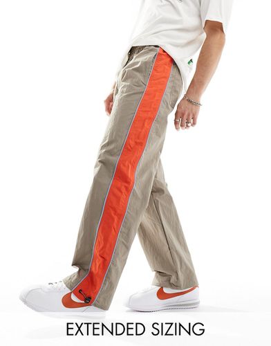 Pantaloni sportivi ampi in nylon marroni con riga laterale arancione - ASOS DESIGN - Modalova