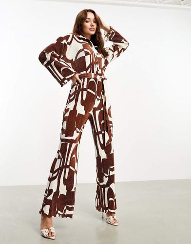 Tuta jumpsuit plissé a fondo ampio con colletto e allacciatura in vita marrone con stampa geometrica - ASOS DESIGN - Modalova