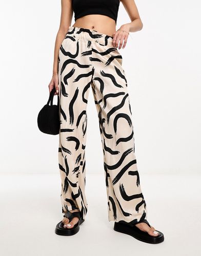 Pantaloni a vita alta e fondo ampio in raso color crema con stampa grafica - JDY - Modalova