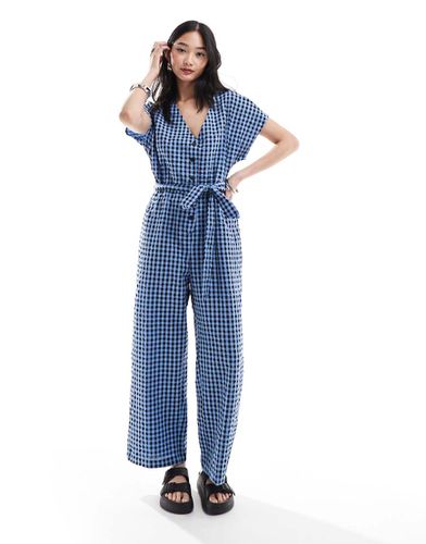 Tuta jumpsuit in seersucker allacciata in vita a quadretti blu e neri - Monki - Modalova