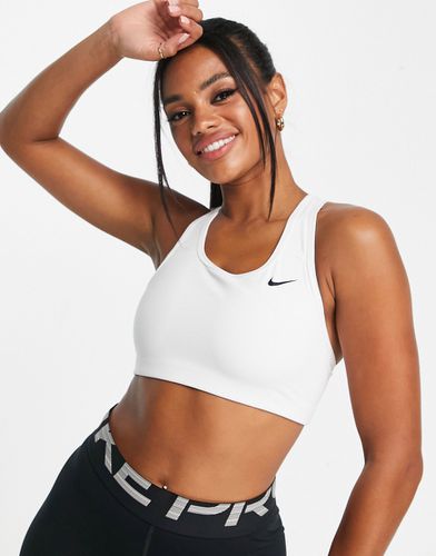 Reggiseno sportivo a sostegno medio con logo Nike - Nike Training - Modalova