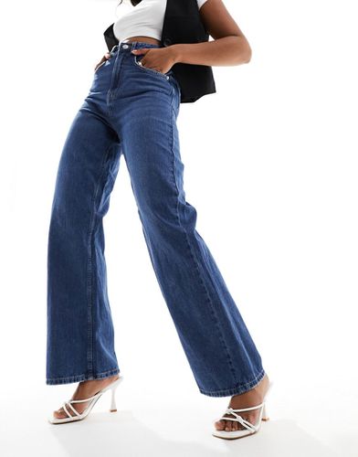 Jeans a fondo ampio in denim scuro con stampa di rosa - Vero Moda - Modalova