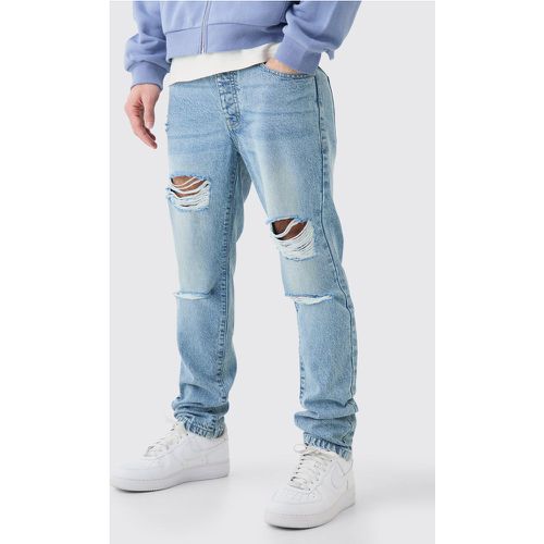 Jeans Slim Fit in denim rigido con strappi all over - boohoo - Modalova