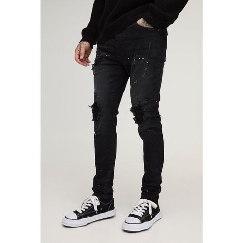 Jeans Tall Skinny Fit stile Biker con schizzi di colore, strappi & rattoppi e zip sul fondo - boohoo - Modalova