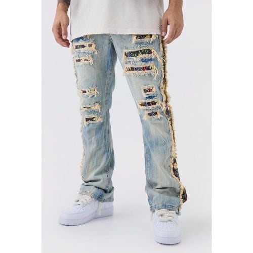 Jeans a zampa Slim Fit in denim rigido con pannelli stile arazzo e strappi & rattoppi - boohoo - Modalova