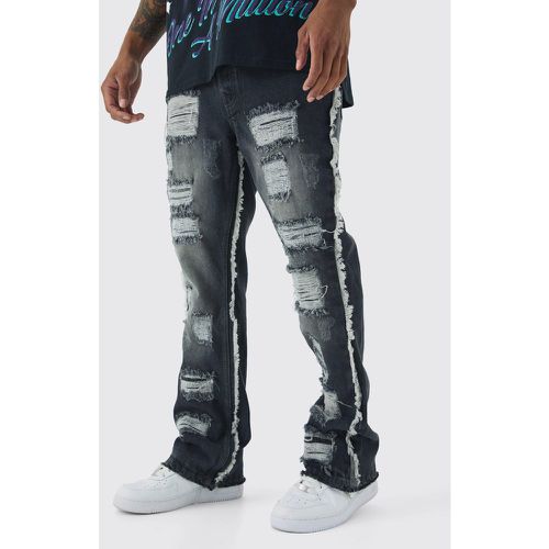 Jeans a zampa Slim Fit con strappi all over e fondo ampio - boohoo - Modalova