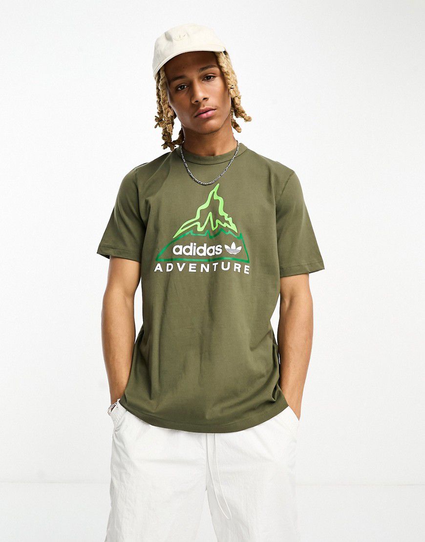 Adventure - T-shirt olive strata con stampa di vulcano - adidas Originals - Modalova