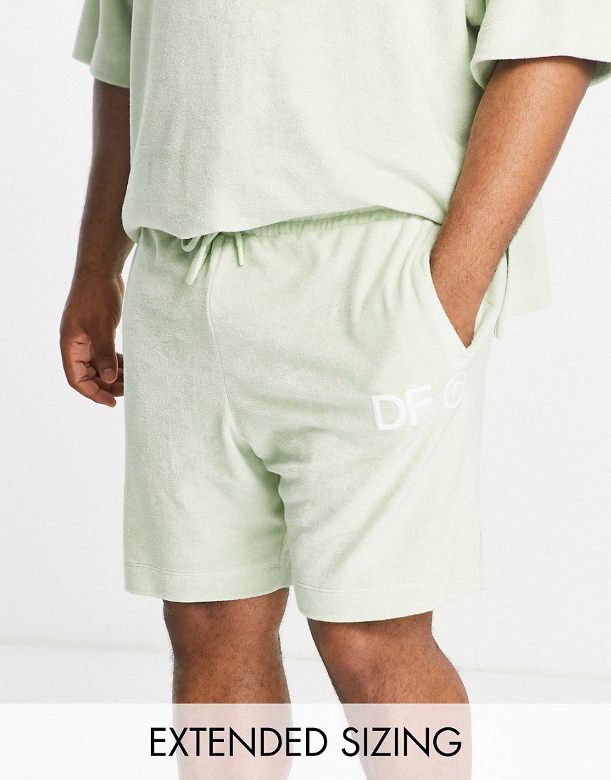 ASOS Dark Future - Pantaloncini comodi in spugna verde chiaro con logo ricamato e spacchi laterali in coordinato - ASOS DESIGN - Modalova