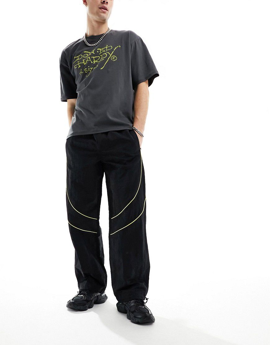 Pantaloni sportivi neri e gialli in nylon lucido a pannelli con profili a contrasto - ASOS DESIGN - Modalova